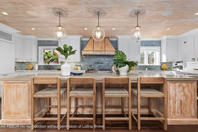 a kitchen with kitchen island granite countertop a stove and a sink