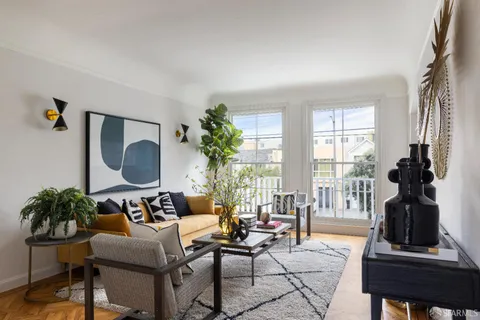 a living room with furniture and a potted plant