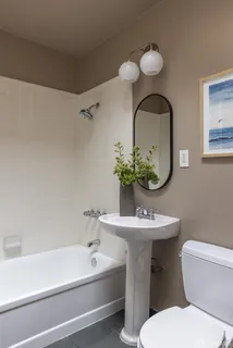 a bathroom with a sink mirror and toilet