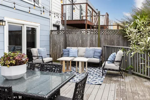 a view of a patio with couches table and chairs and potted plants