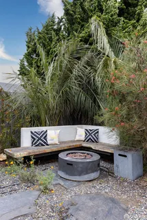 a view of a backyard with plants and outdoor seating