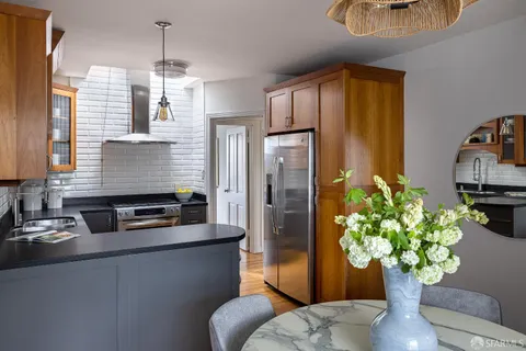 a kitchen with stainless steel appliances granite countertop a refrigerator a stove a sink dishwasher and a dining table with garden view