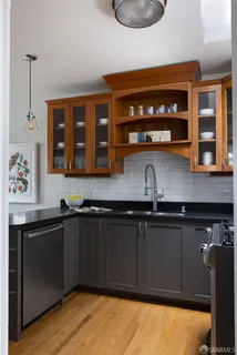 a kitchen with granite countertop a sink cabinets and wooden floor