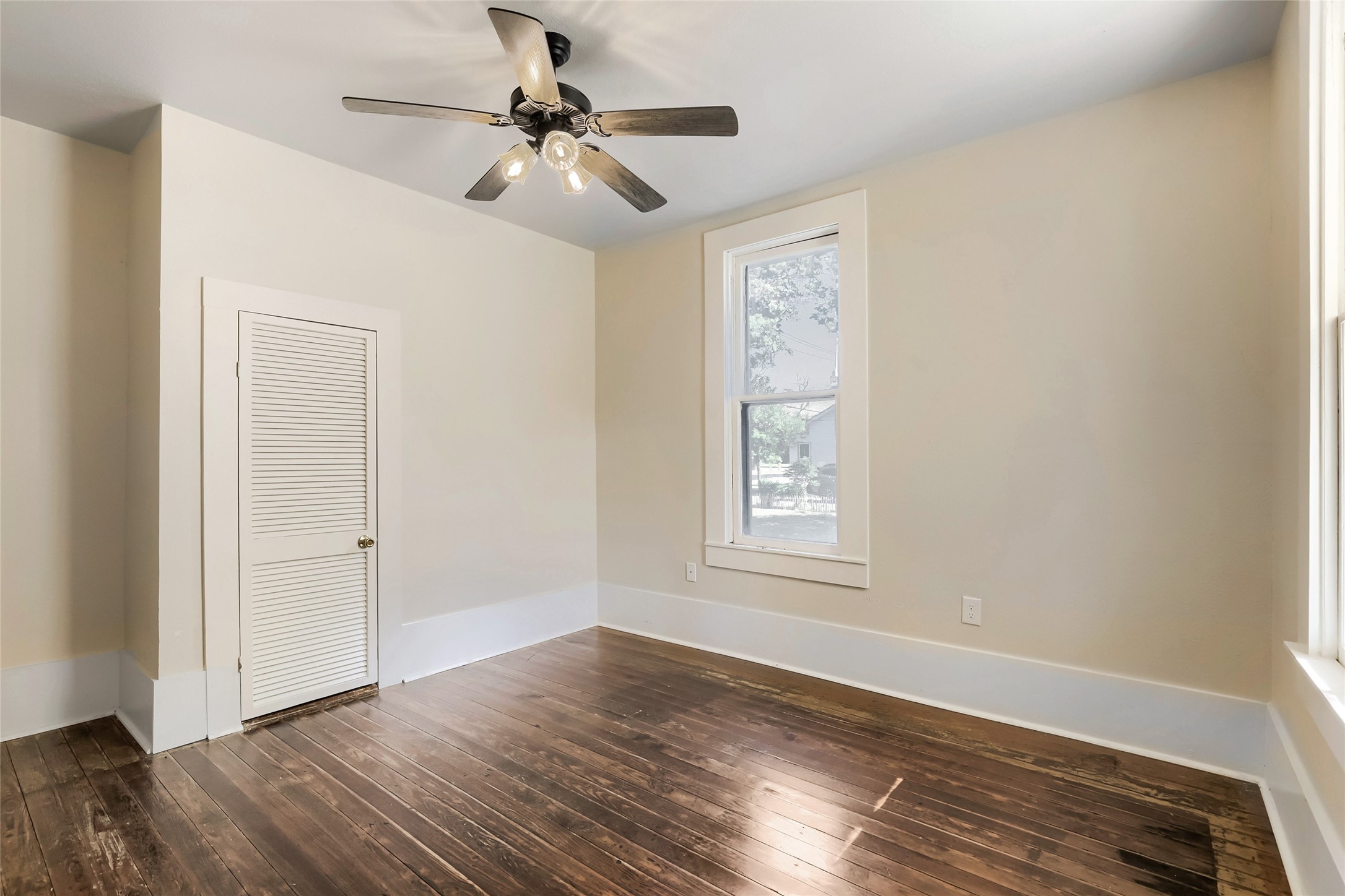208 North Ave B Elgin, TX 78621 - Photo 17 of 29 an empty room with wooden floor chandelier fan and windows