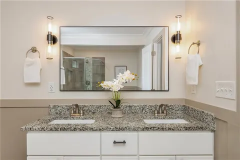 a bathroom with a granite countertop sink and a mirror