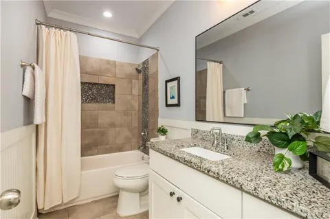 a bathroom with a granite countertop sink a toilet and shower