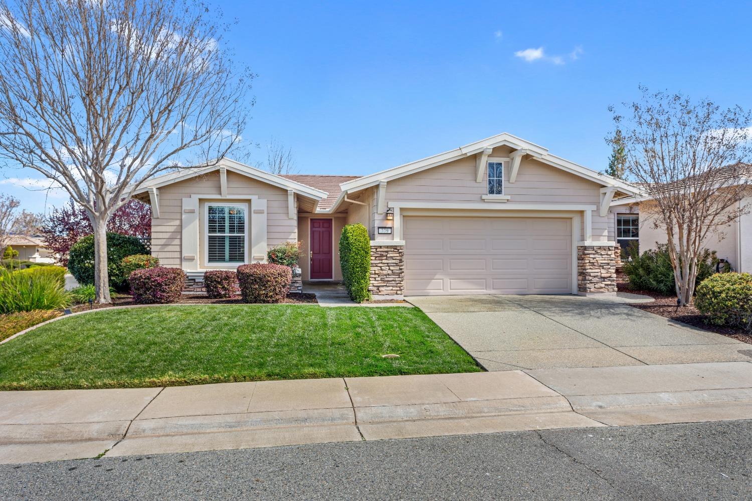 a front view of a house with a garden and trees