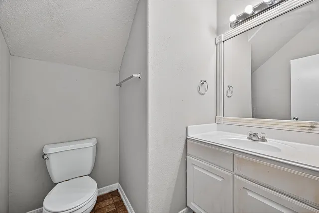 an empty room with wooden floor chandelier fan and windows