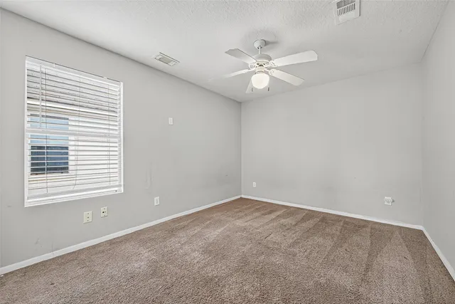 a view of an empty room with a chandelier fan
