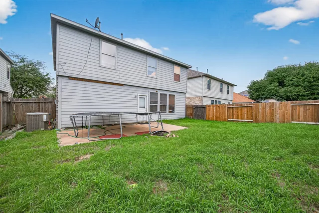 a view of a backyard with table and chairs plants wooden fence