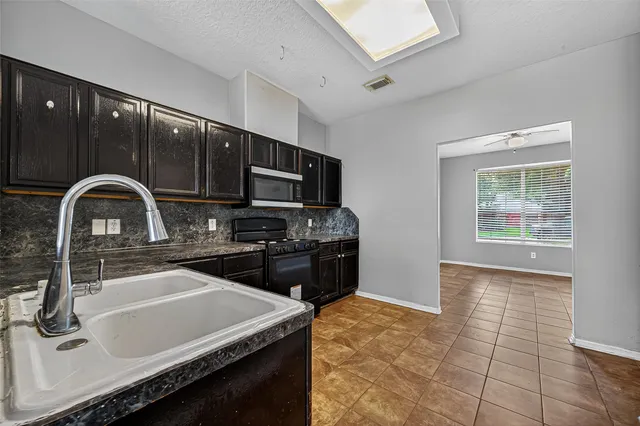 a kitchen with stainless steel appliances granite countertop a stove sink and cabinets