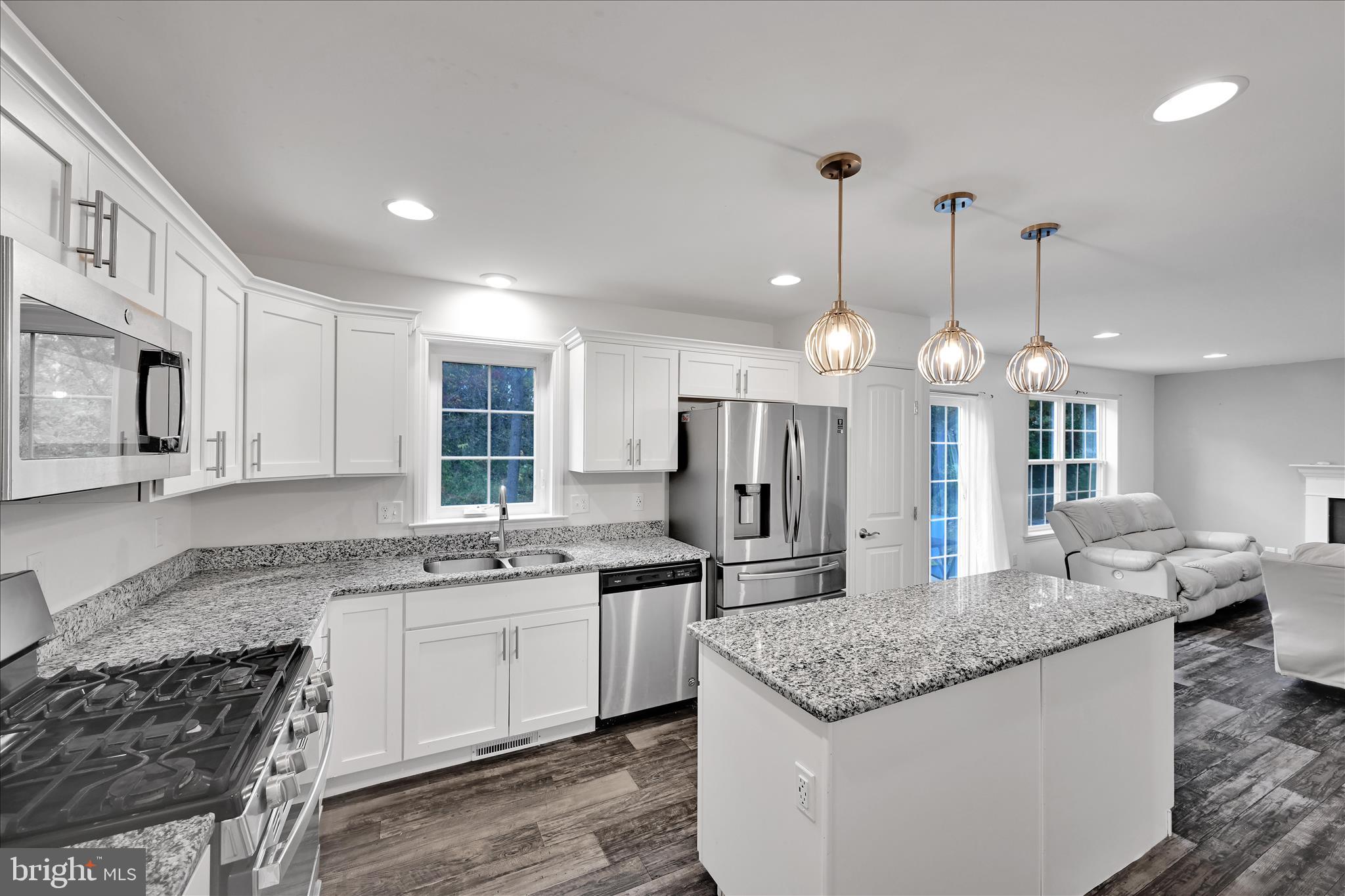 1485 Graystone Road Manheim, PA 17545 - Photo 15 of 43 a kitchen with stainless steel appliances granite countertop a sink a stove a refrigerator and island with wooden floor