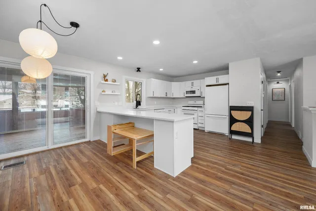 a kitchen with stainless steel appliances granite countertop a stove refrigerator and cabinets with wooden floor