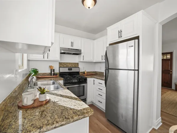 a kitchen with granite countertop a refrigerator stove and sink
