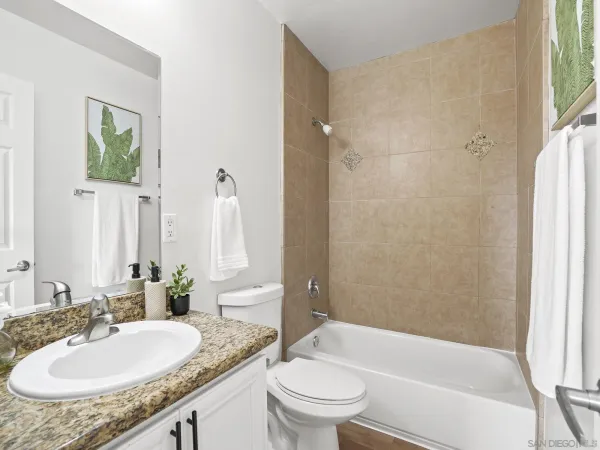 a bathroom with a granite countertop sink toilet and shower