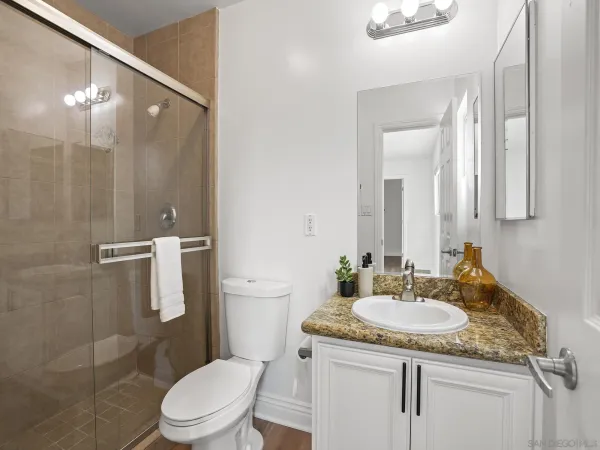 a bathroom with a granite countertop sink toilet and shower