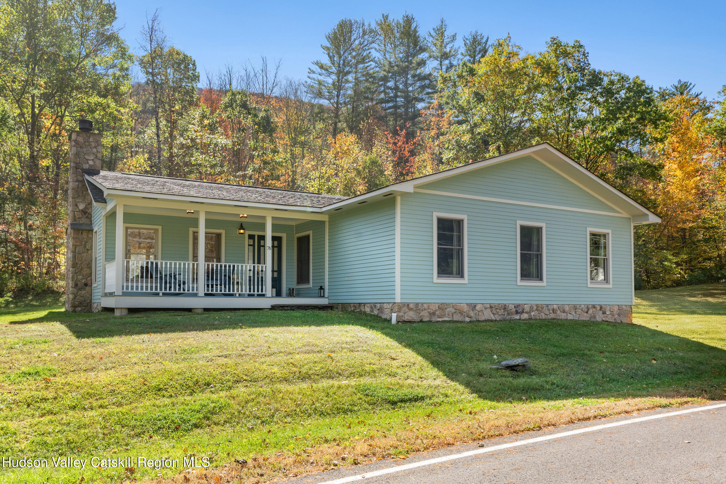a view of a house with a yard and potted plants