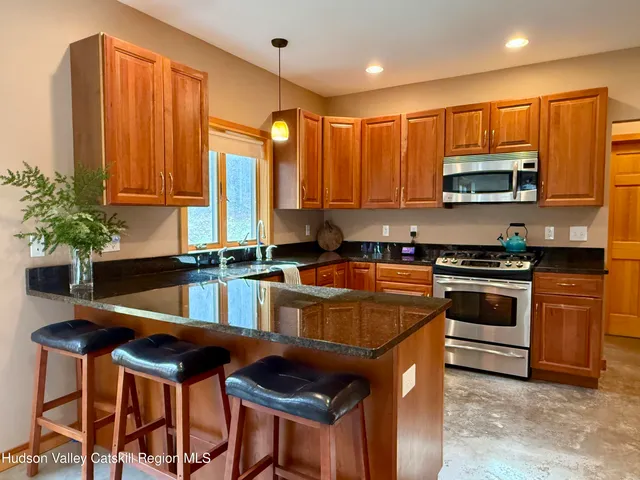 a kitchen with stainless steel appliances granite countertop a stove a sink and a refrigerator