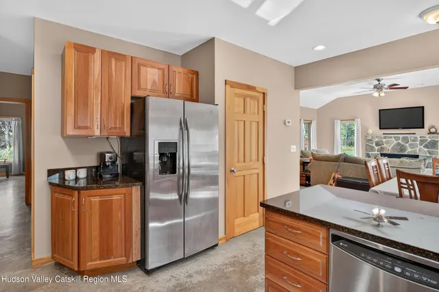 a kitchen with granite countertop a refrigerator and a stove top oven