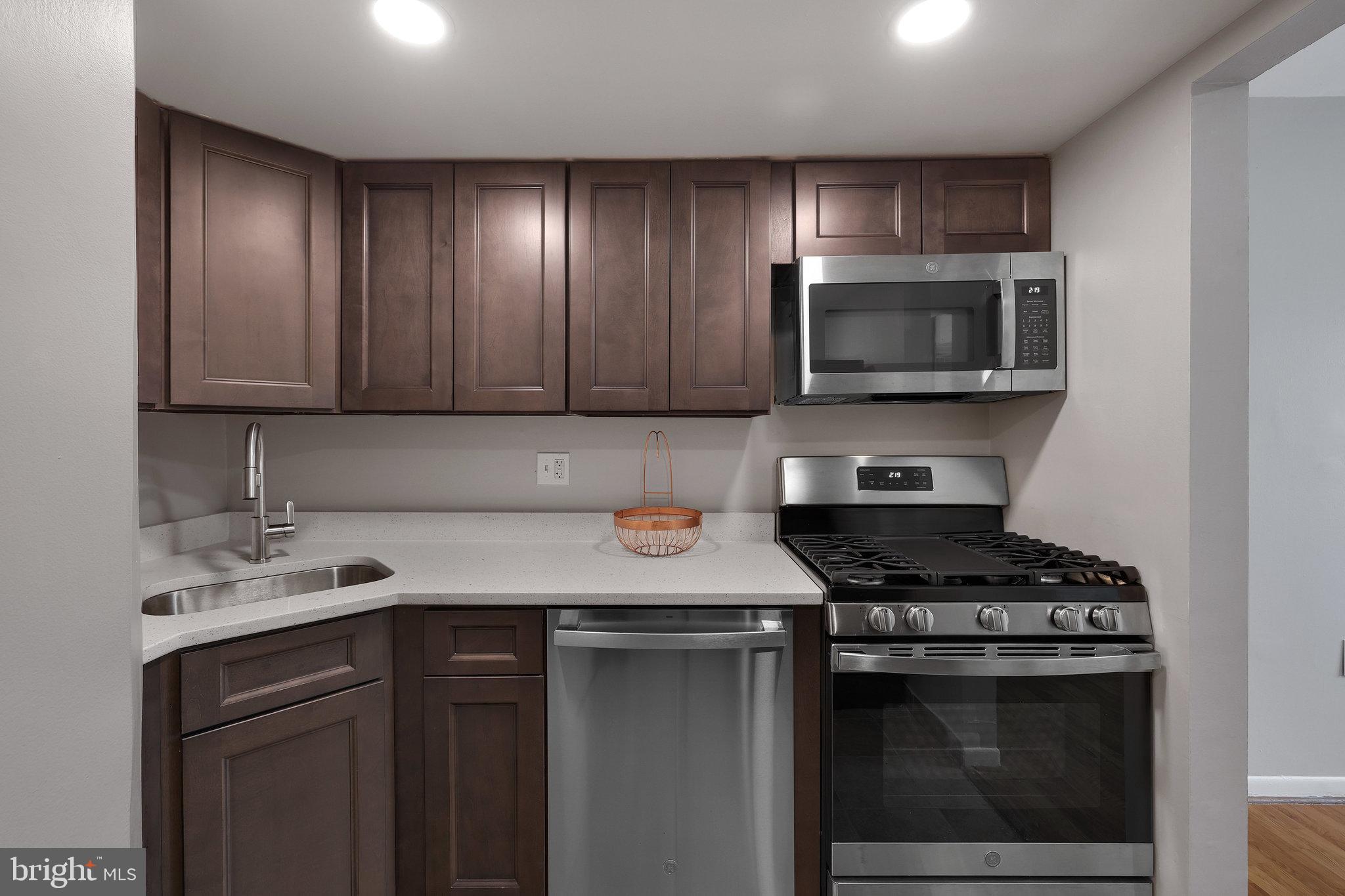 1554 Northgate Square, Unit 2A Reston, VA 20190 - Photo 3 of 11 a kitchen with stainless steel appliances a stove a microwave cabinets and a sink