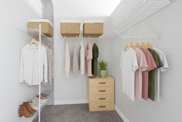 a view of walk in closet with clothes and shoes