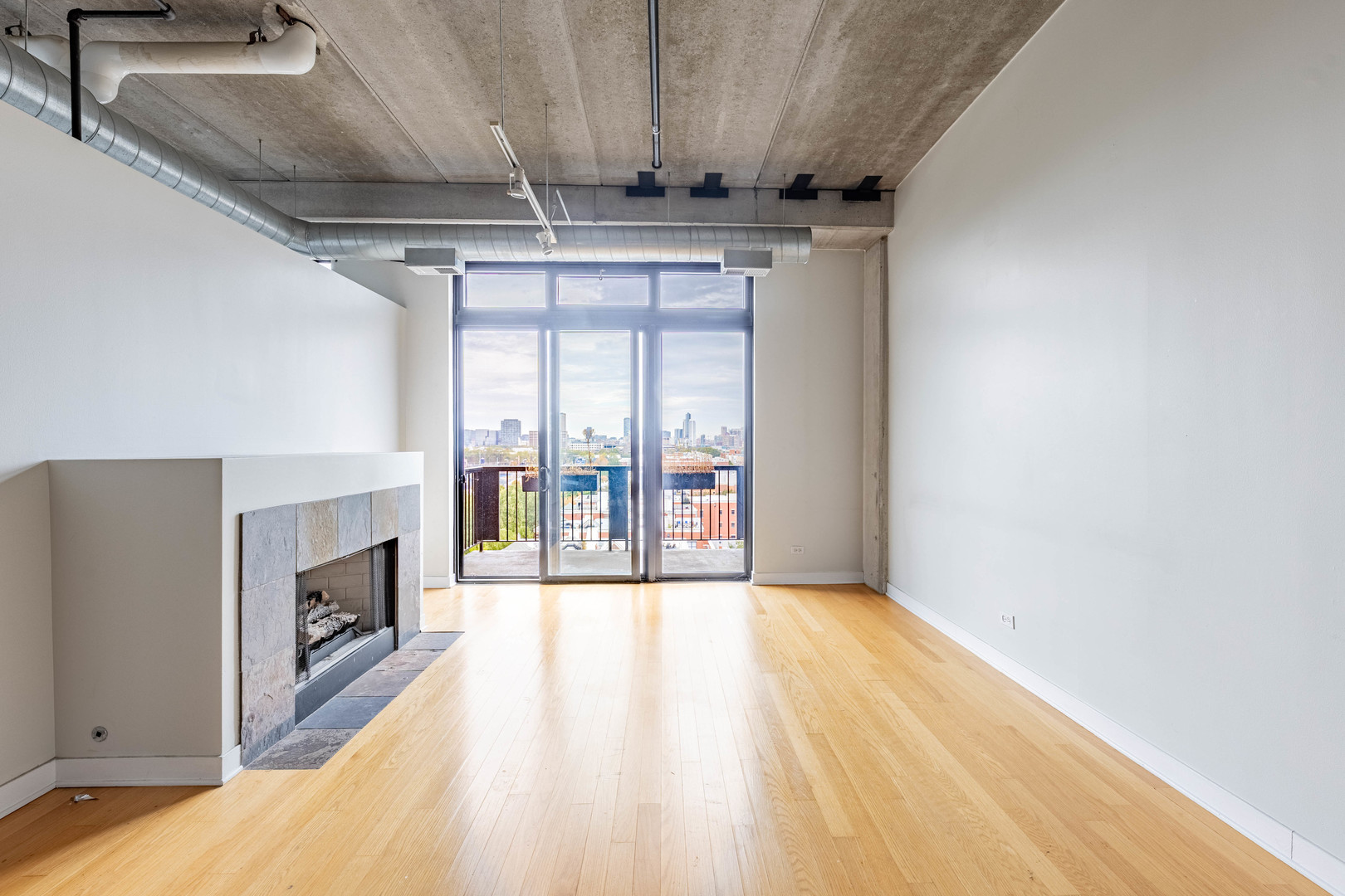 811 West 15th Place, Unit 806 Chicago, IL 60608 - Photo 4 of 35 a view of an empty room with wooden floor and a fireplace