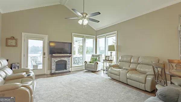 a living room with furniture a flat screen tv and a large window with the view