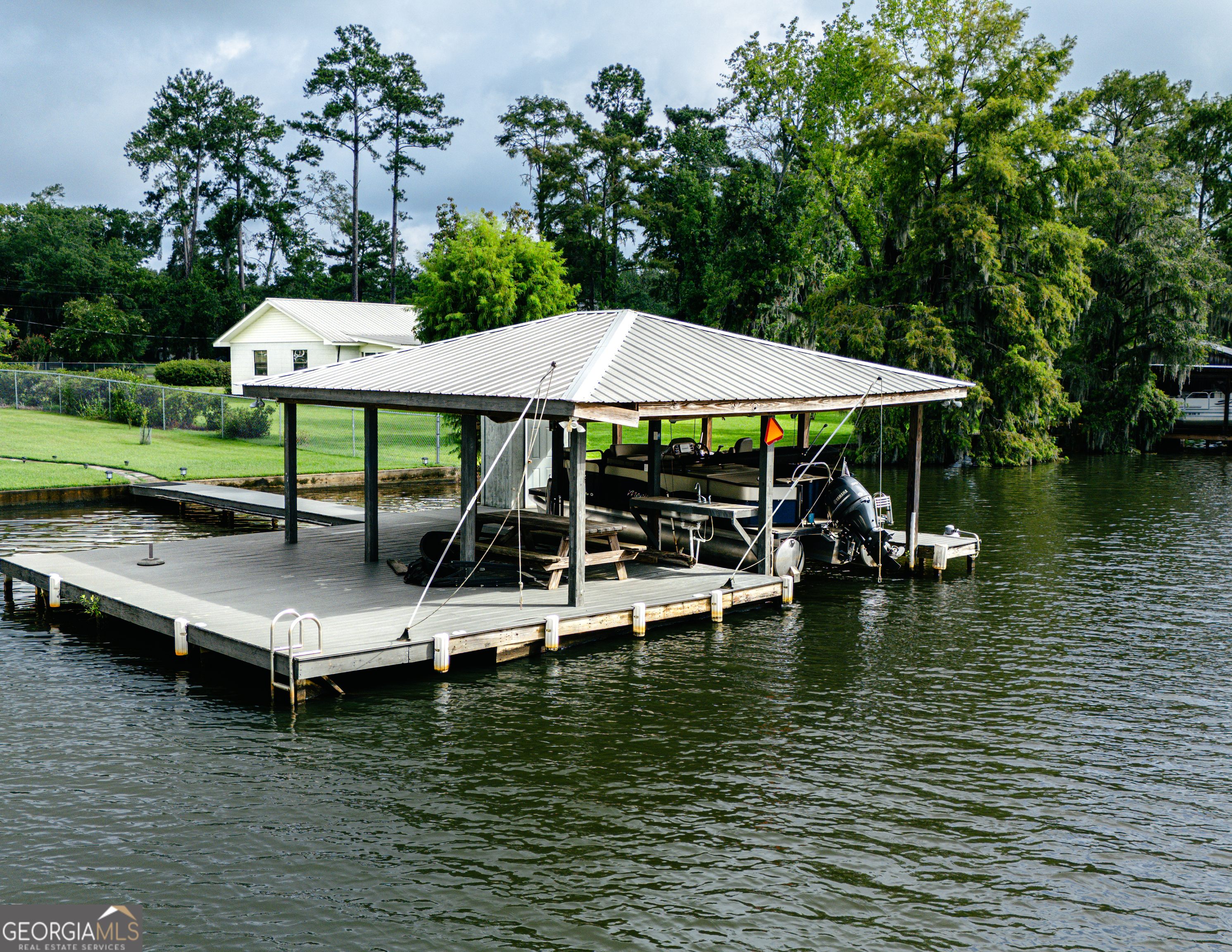 475 Cedar Creek Road North Cordele, GA 31015 - Photo 9 of 50 a view of a lake with table and chairs under an umbrella