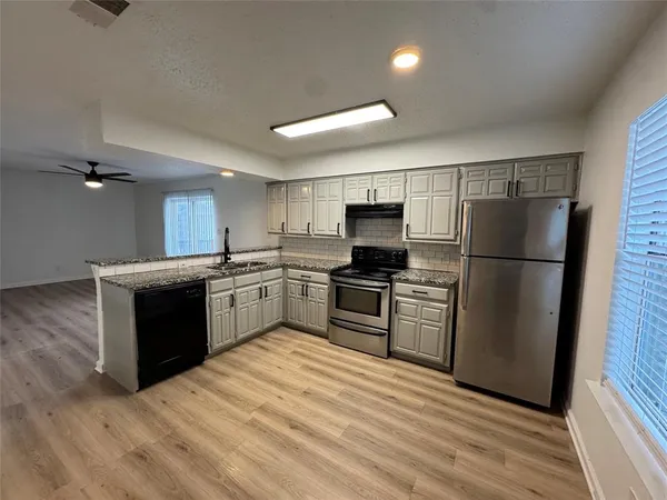 a kitchen with a refrigerator sink and wooden floor