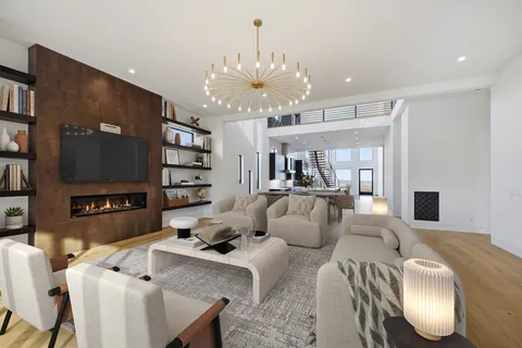 a living room with furniture a chandelier and a flat screen tv