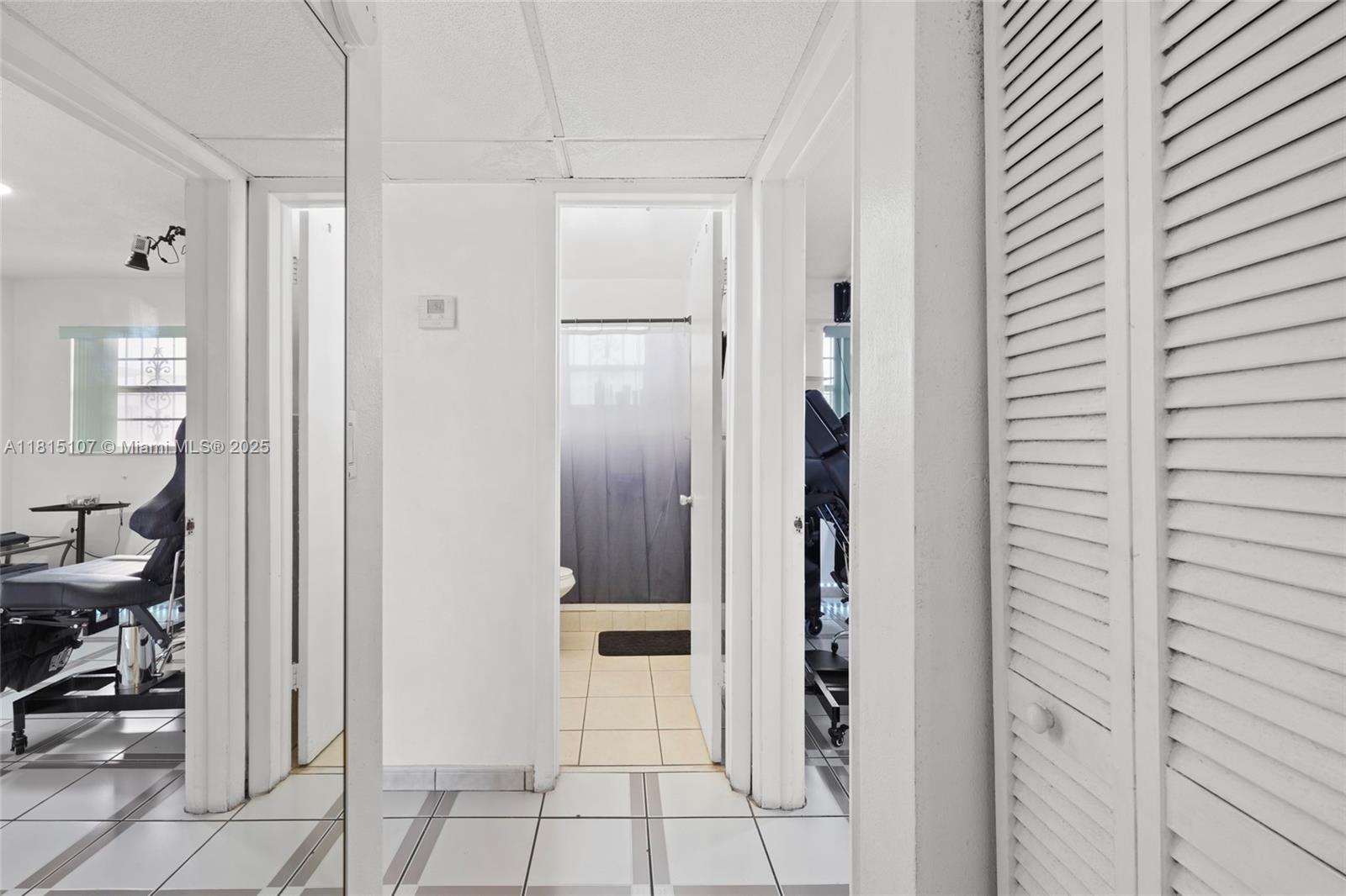 2498 Southwest 17th Avenue, Unit 4311 Miami, FL 33133 - Photo 12 of 19 a bathroom with a glass shower door and a mirror