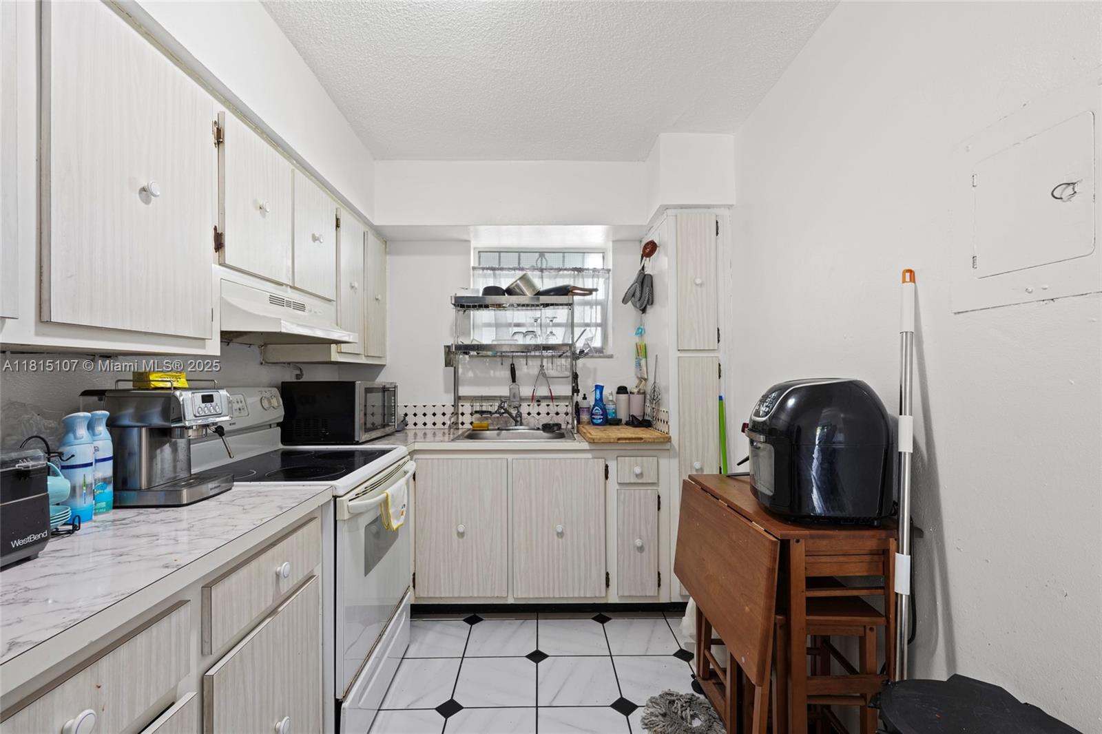 2498 Southwest 17th Avenue, Unit 4311 Miami, FL 33133 - Photo 14 of 19 a kitchen with granite countertop a sink a stove and cabinets