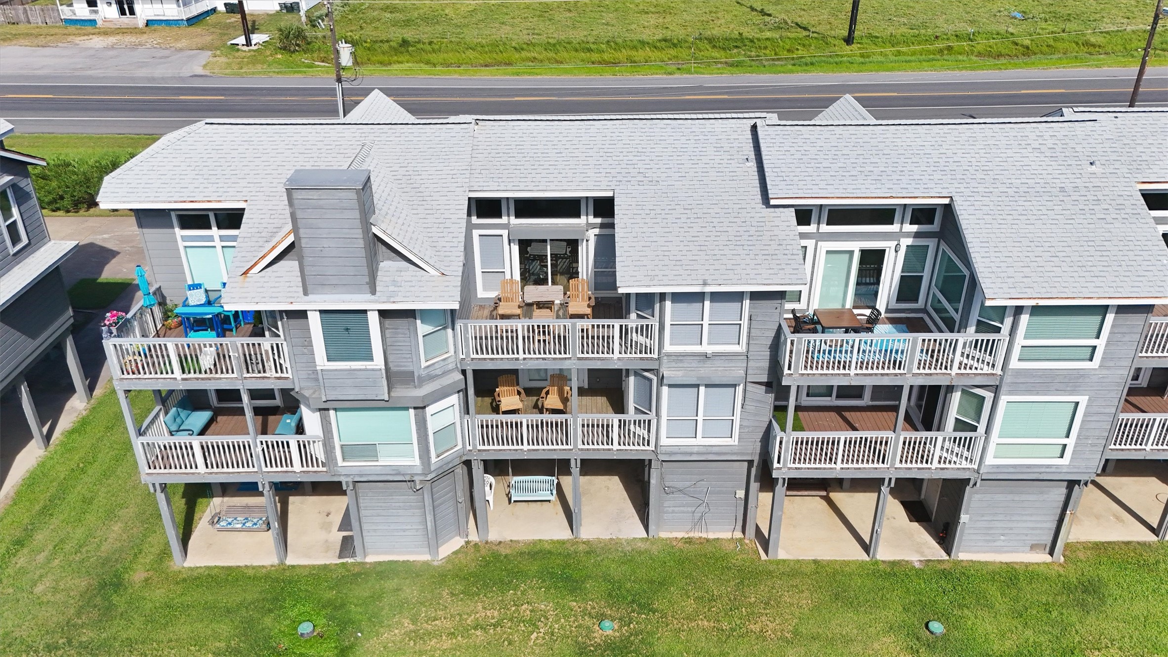 17607 Termini-San Luis Pass Road Galveston, TX 77554 - Photo 2 of 42 The back of the townhome features multiple balconies perfect for relaxing outdoors or entertaining with ocean breezes. Large windows and sliding glass doors fill the home with natural light, enhancing the indoor-outdoor living experience.