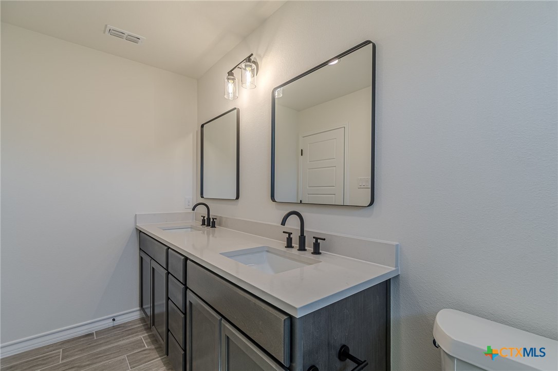 403 North Bauer Street Seguin, TX 78155 - Photo 11 of 27 a bathroom with a sink vanity and a toilet
