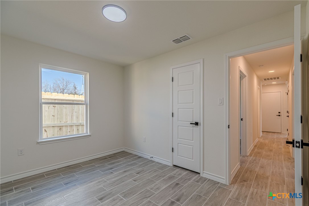403 North Bauer Street Seguin, TX 78155 - Photo 16 of 27 an empty room with wooden floor and windows