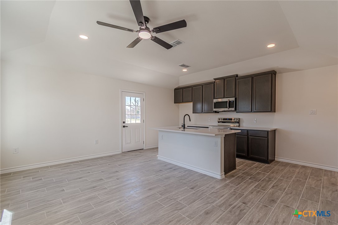 403 North Bauer Street Seguin, TX 78155 - Photo 19 of 27 a kitchen with a sink cabinets stainless steel appliances and a window