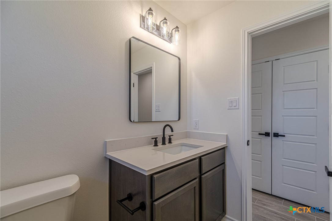 403 North Bauer Street Seguin, TX 78155 - Photo 4 of 27 a bathroom with a toilet sink and mirror