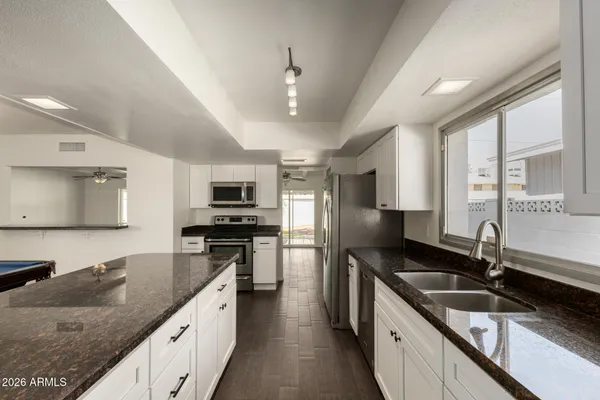 a kitchen with stainless steel appliances granite countertop a sink stove and refrigerator
