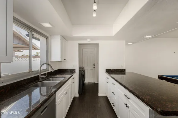 a kitchen with granite countertop a sink stove and cabinets