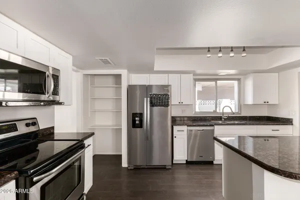 a kitchen with stainless steel appliances a refrigerator a stove and a sink
