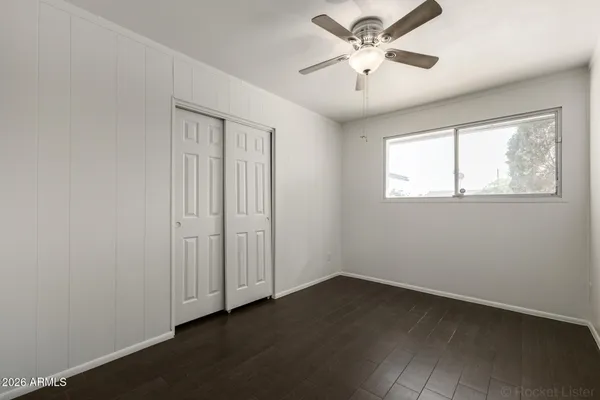 an empty room with a window and a ceiling fan
