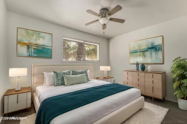 a bedroom with a large bed and a chandelier