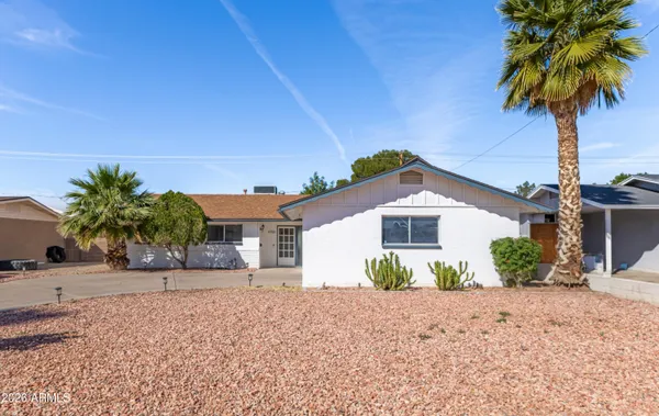 a view of a house with a yard and palm trees