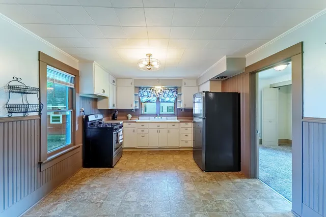 a view of kitchen with refrigerator and window