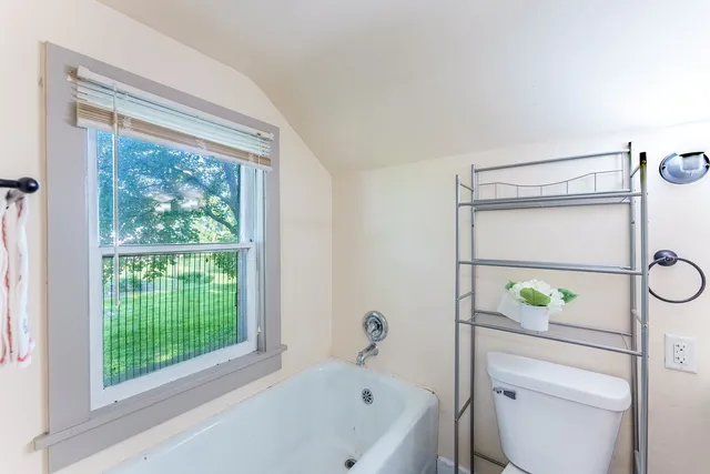 a bathroom with a toilet shower and window