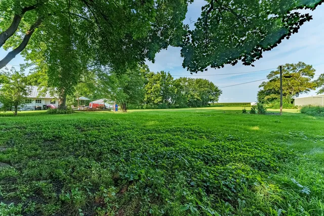 a backyard of a house with lots of green space and lake view