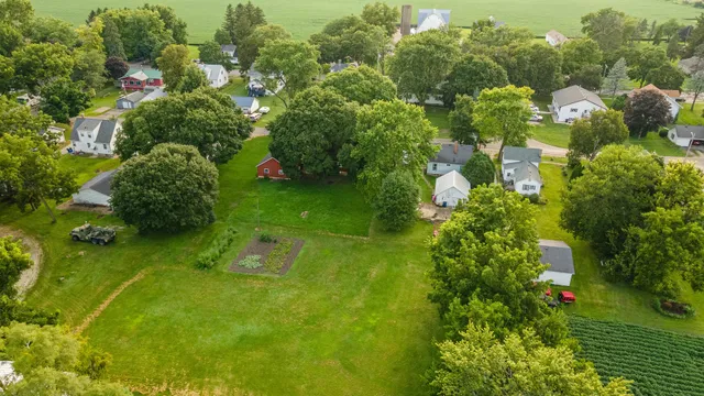 an aerial view of residential houses with outdoor space and trees