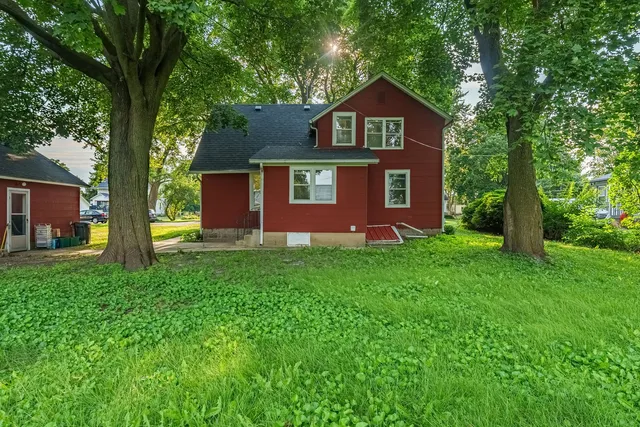 a front view of a house with a yard and trees