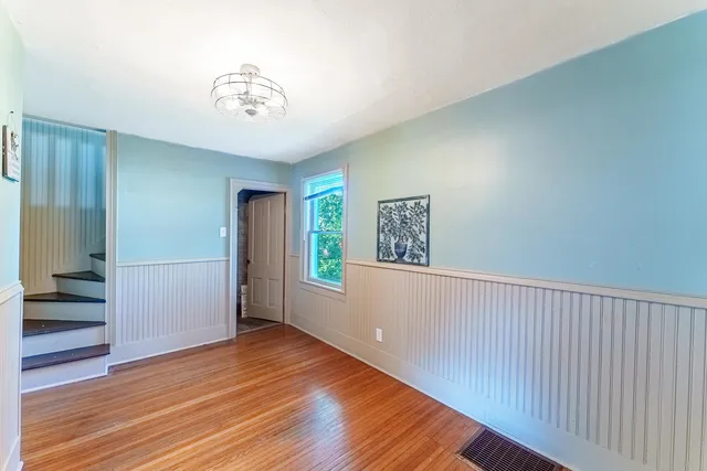 a kitchen with granite countertop stainless steel appliances a refrigerator cabinets and wooden floor