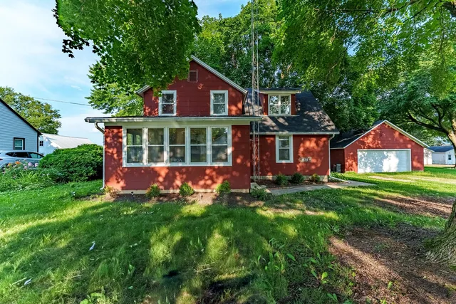 a view of a house with a big yard and large trees